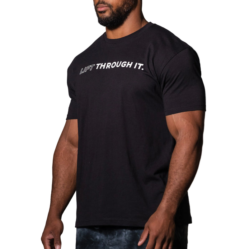 Load image into Gallery viewer, Person wearing a black t-shirt with 'LIFT THROUGH IT.' text on a plain background