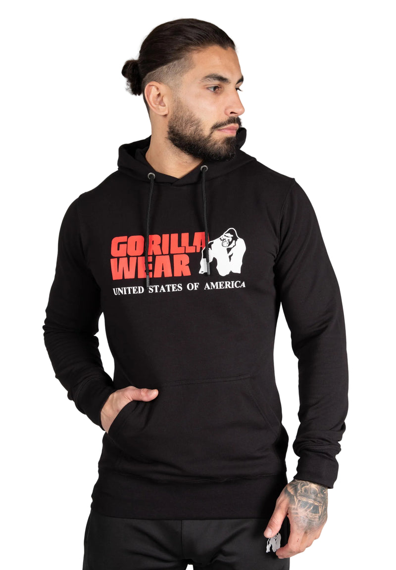 Load image into Gallery viewer, A male model wearing a black hoodie with the Gorilla Wear logo on the chest. The hoodie features a drawstring hood and elastic ribbed cuffs.