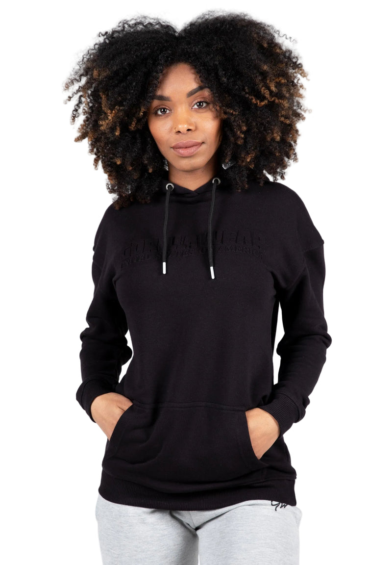 Load image into Gallery viewer, A woman wearing a black oversized hoodie with a hood, featuring a relaxed fit and drop shoulders.