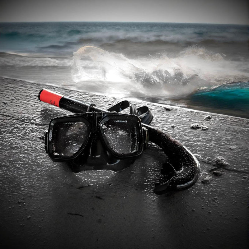 Load image into Gallery viewer, Diving mask and snorkel on a sandy beach with ocean waves in the background