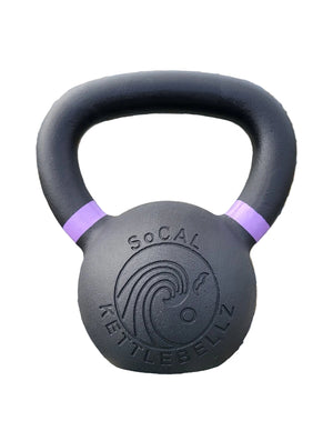 Black kettlebell with purple bands on pebbles