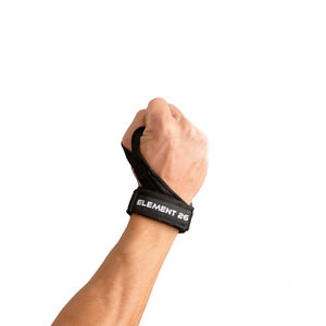 Hand wearing a black wrist support brace with text on a light gray background