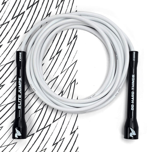 A coiled white jump rope with black handles featuring the text 'ELITE JUMPS' laid out on a surface with a black and white pattern.